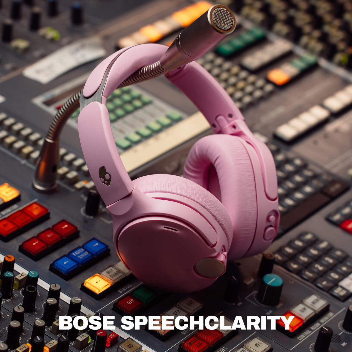 Candy | Pink Crusher 1080 over-ear headphones with a boom microphone resting on a professional audio mixing board. The text 'BOSE SPEECHCLARITY' is displayed at the bottom.