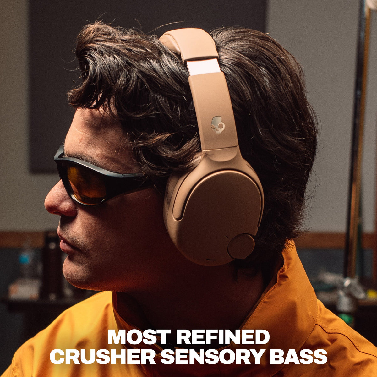 Primer | A man in profile wearing tan crusher 1080 over-ear headphones and dark sunglasses, with bold text at the bottom reading 'MOST REFINED CRUSHER SENSORY BASS'.