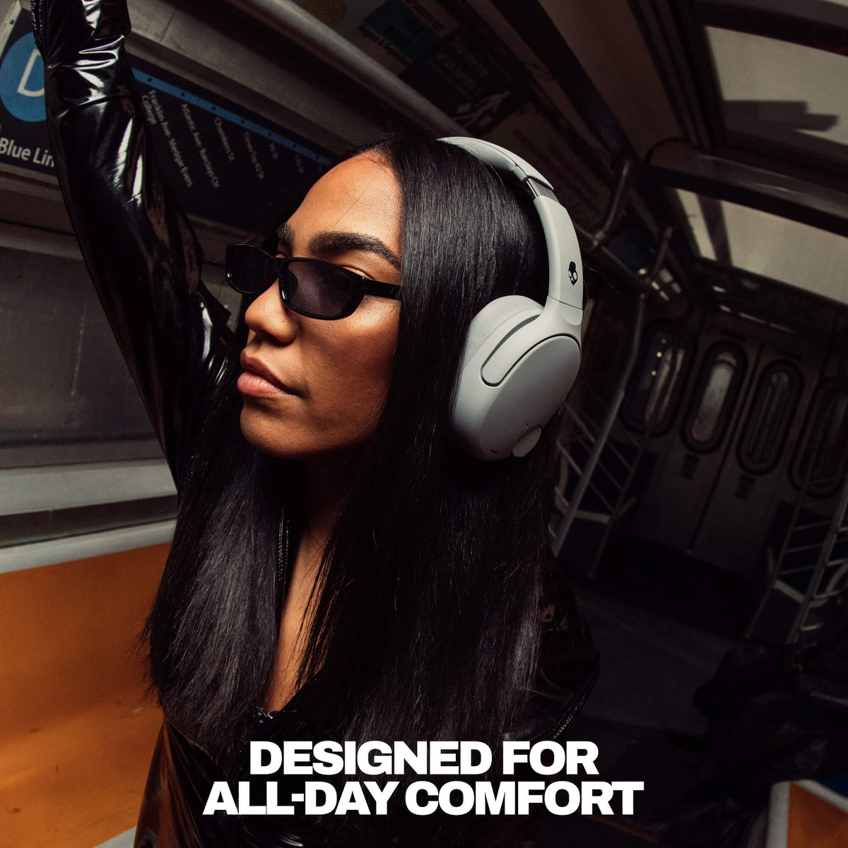 Cement | Person wearing Crusher 720 headphones and sunglasses inside a vehicle with text 'DESIGNED FOR ALL-DAY COMFORT'.