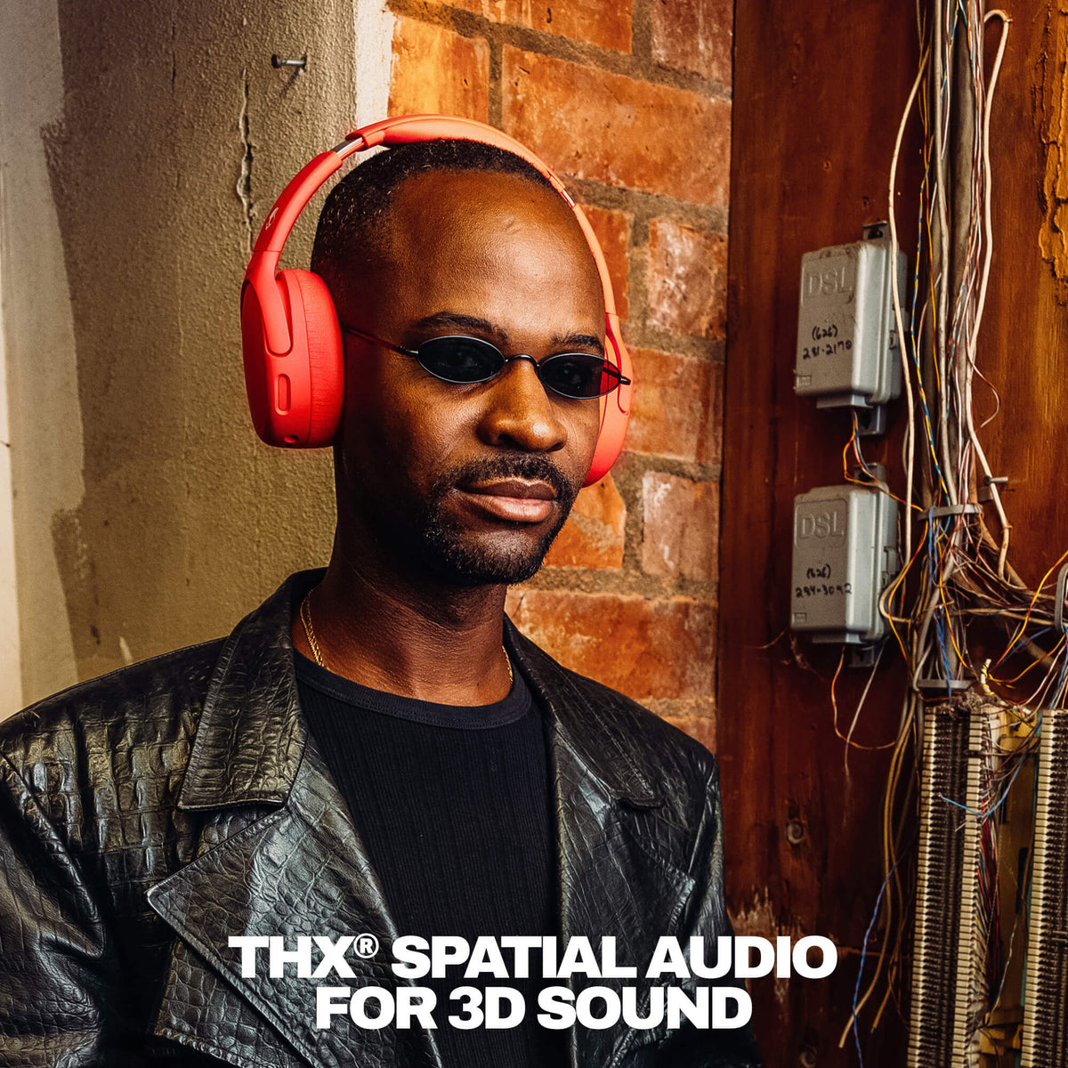 Plasma | Man wearing red Crusher 720 headphones and sunglasses with 'THX Spatial Audio' branding against a brick wall.